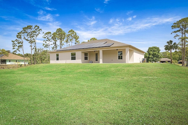 17854 N 71st Ln N, The Acreage, FL 33470 - rear view of house with solar panels, stucco siding, and a lawn