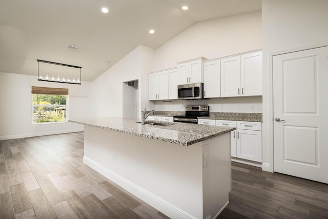 17854 N 71st Ln N, The Acreage, FL 33470 - kitchen with stainless steel appliances, a sink, high vaulted ceiling, light stone countertops, and a kitchen island with sink