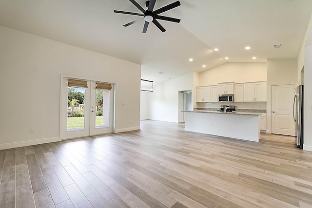 17854 N 71st Ln N, The Acreage, FL 33470 - unfurnished living room with ceiling fan, recessed lighting, light wood-style floors, high vaulted ceiling, and french doors