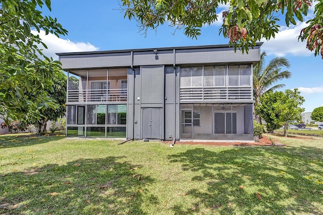 rear view of property featuring a sunroom and a yard