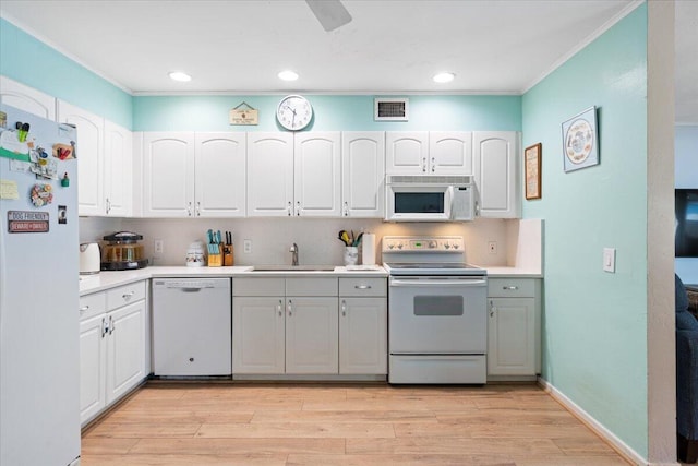 265 NE 13th St, Delray Beach, FL 33444 - kitchen with white appliances, a sink, crown molding, light wood-style floors, and light countertops