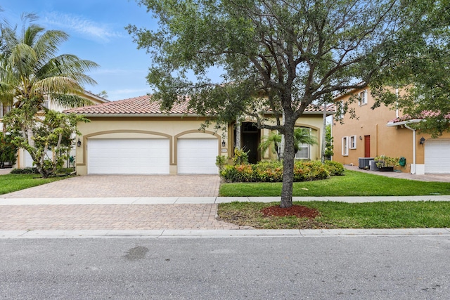 707 Cresta Cir, West Palm Beach, FL 33413 - mediterranean / spanish-style house featuring a tiled roof, driveway, a front lawn, an attached garage, and stucco siding