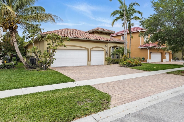 707 Cresta Cir, West Palm Beach, FL 33413 - mediterranean / spanish-style home featuring a tiled roof, a front yard, a garage, decorative driveway, and stucco siding
