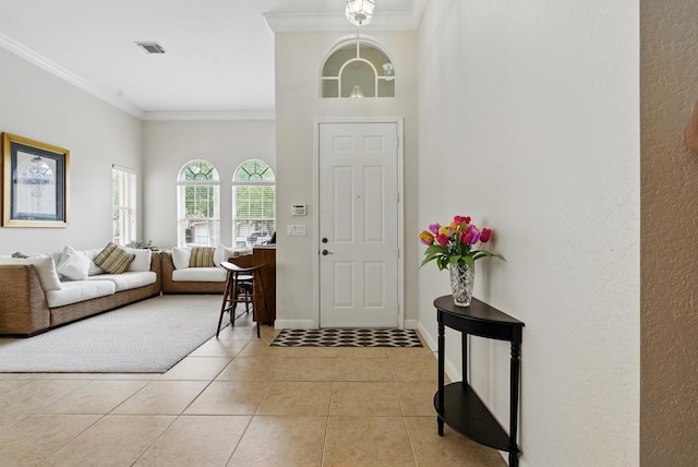 707 Cresta Cir, West Palm Beach, FL 33413 - entryway with visible vents, ornamental molding, a textured wall, light tile patterned flooring, and baseboards