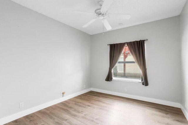 spare room featuring wood finished floors, baseboards, and ceiling fan