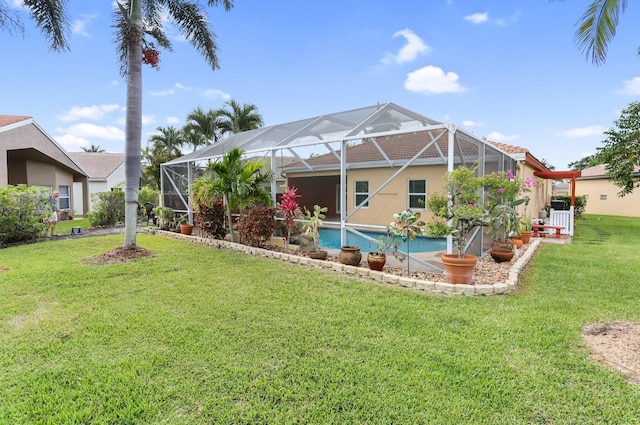 rear view of house featuring a yard, a lanai, an outdoor pool, and stucco siding