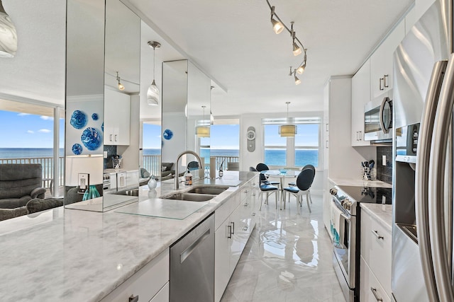 kitchen with a sink, appliances with stainless steel finishes, white cabinets, and track lighting