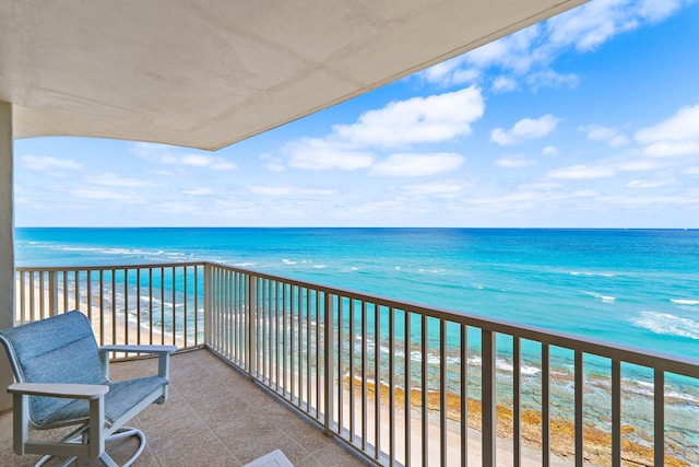balcony with a water view and a view of the beach