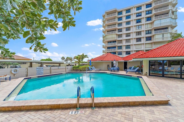 pool with fence and a patio