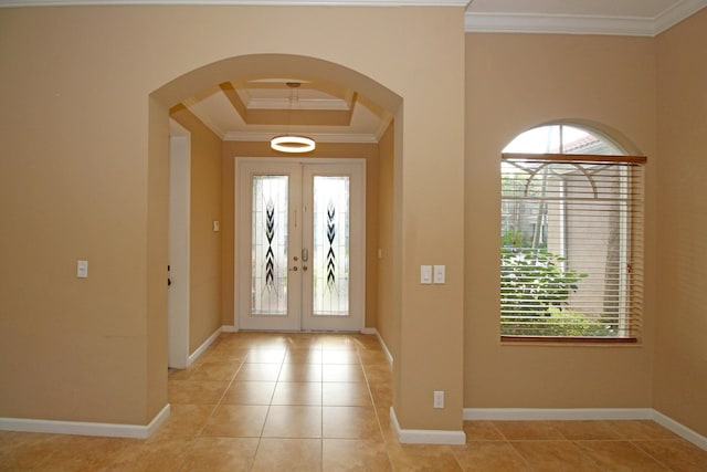 entryway with a wealth of natural light, ornamental molding, french doors, and light tile patterned floors