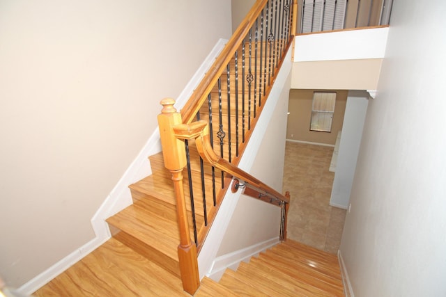 stairs with wood finished floors and baseboards