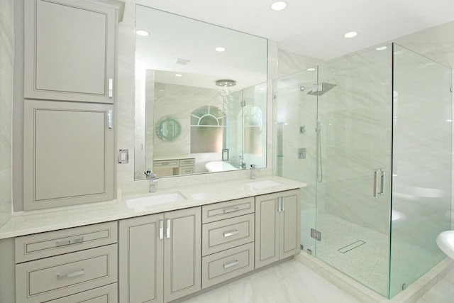 bathroom featuring a sink, a marble finish shower, marble finish floor, double vanity, and recessed lighting