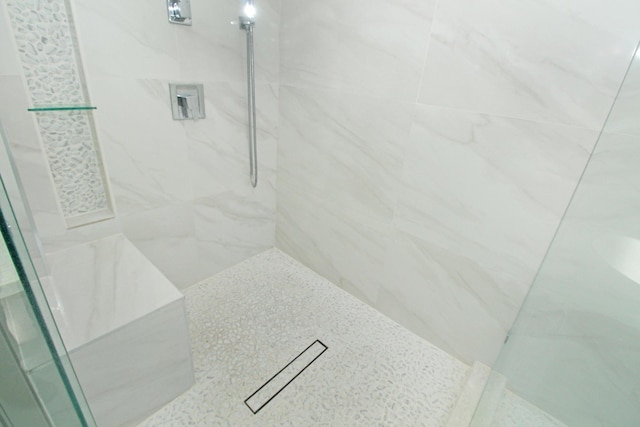 bathroom featuring a marble finish shower