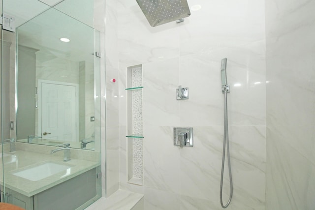 full bathroom with vanity and a marble finish shower