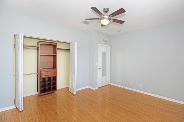 unfurnished bedroom featuring light wood-style floors, baseboards, visible vents, and a closet
