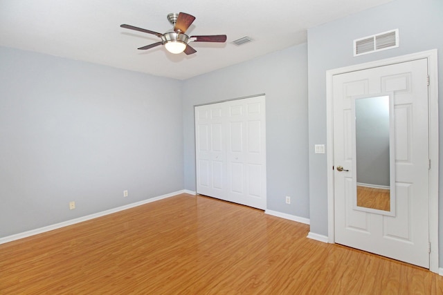 unfurnished bedroom with light wood-type flooring, baseboards, visible vents, and a closet