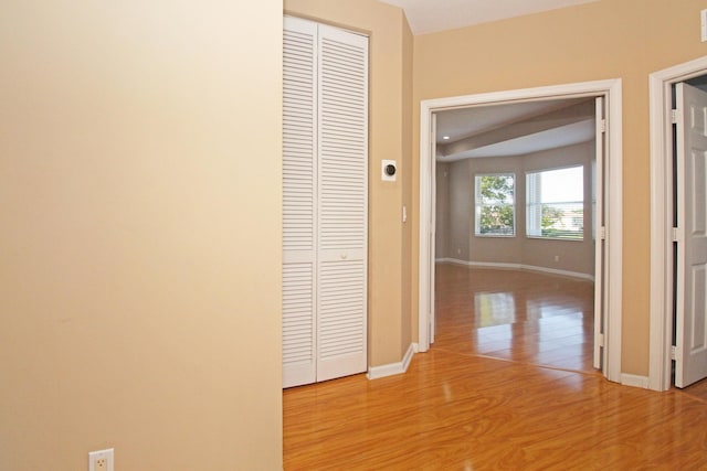 hall featuring baseboards and light wood-type flooring