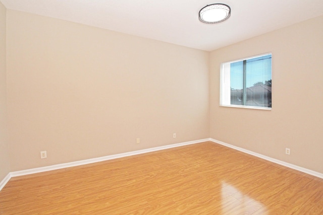 unfurnished room with baseboards and light wood-style floors