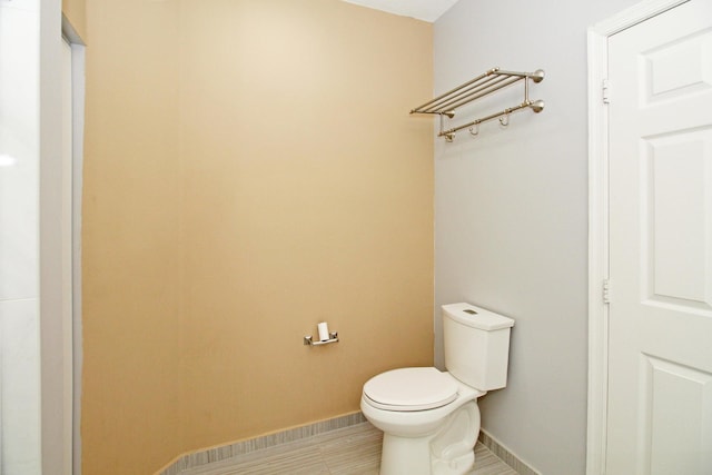 bathroom with toilet and baseboards