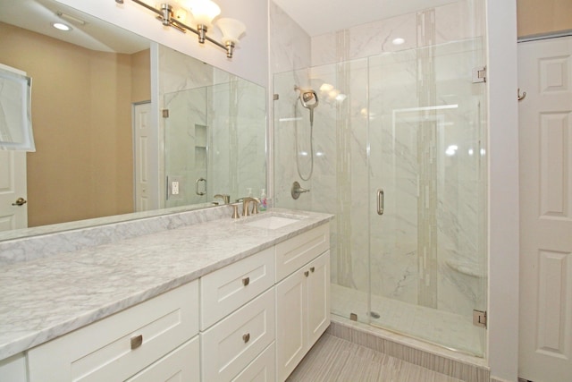 bathroom with tile patterned flooring, vanity, and a marble finish shower