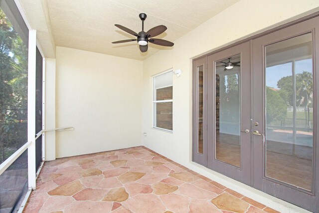 unfurnished sunroom featuring ceiling fan and french doors