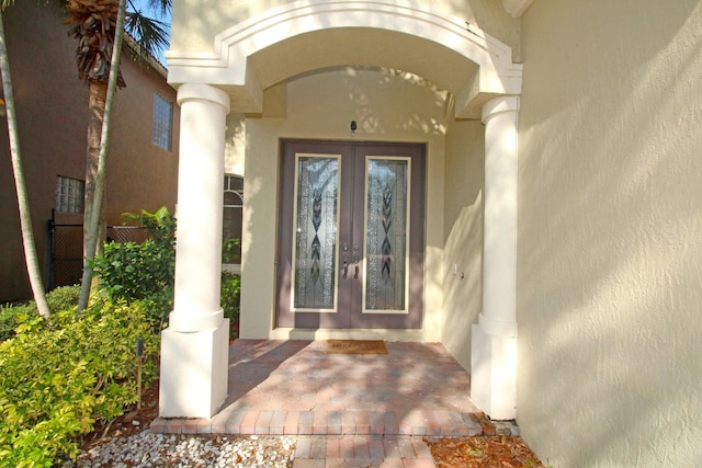 entrance to property featuring stucco siding and french doors