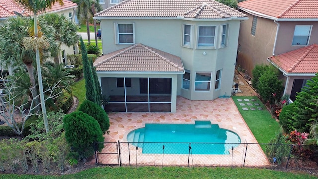 rear view of house with a fenced backyard, a tile roof, and a patio