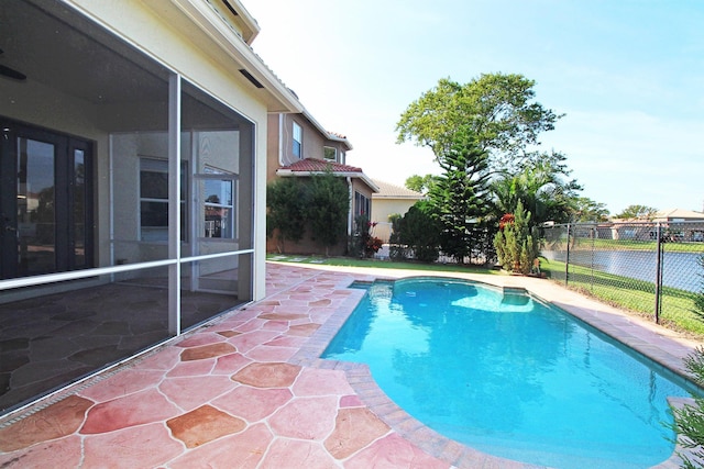 view of pool with fence, a patio area, a sunroom, and a fenced in pool