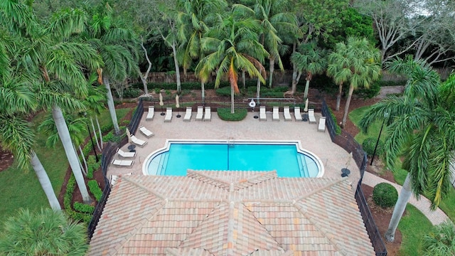 community pool with fence and a patio