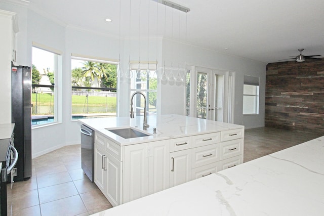 kitchen featuring crown molding, a ceiling fan, a sink, light tile patterned floors, and stainless steel appliances