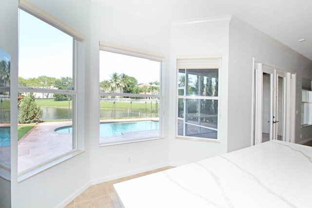 unfurnished bedroom featuring light tile patterned flooring, crown molding, baseboards, and multiple windows