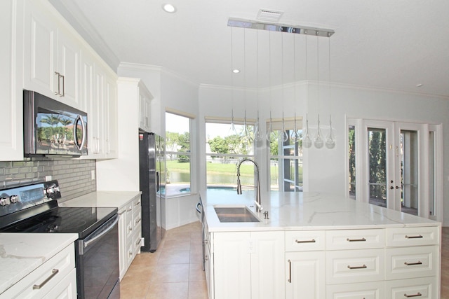 kitchen with a sink, stainless steel microwave, a center island with sink, electric range, and refrigerator with ice dispenser