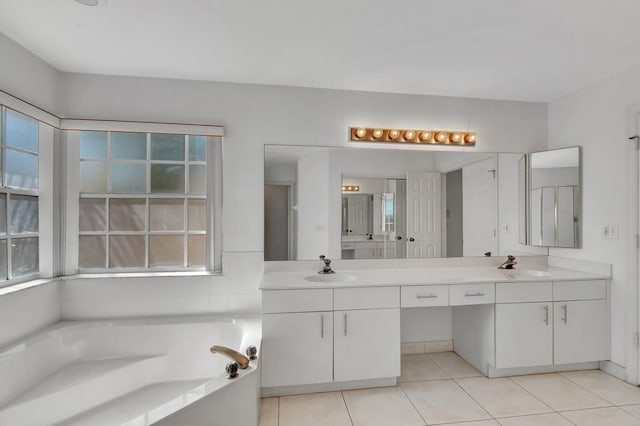 bathroom featuring a sink, tile patterned flooring, a garden tub, and double vanity