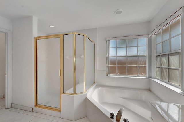 full bathroom featuring tile patterned flooring, a bath, and a shower stall