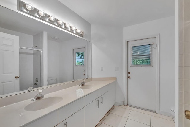 full bath featuring a sink, an enclosed shower, tile patterned floors, and toilet