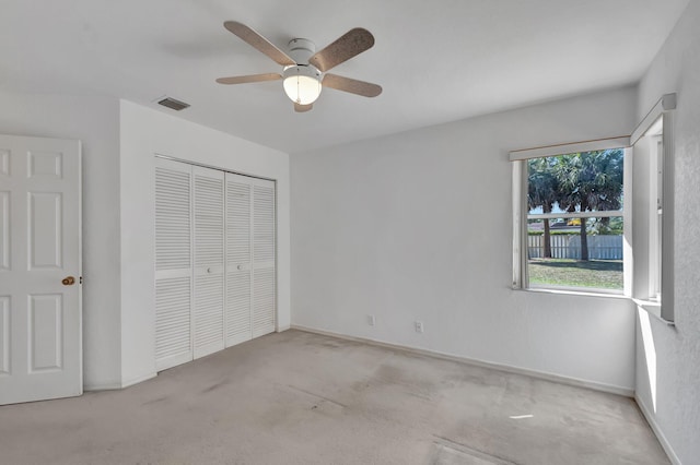 unfurnished bedroom with ceiling fan, carpet, baseboards, visible vents, and a closet