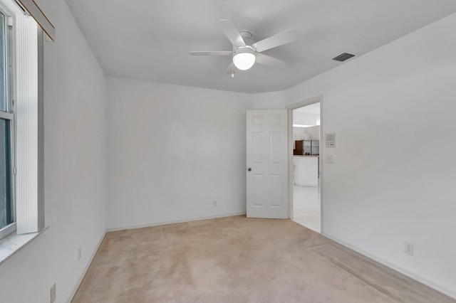 spare room with visible vents, a ceiling fan, carpet, and baseboards