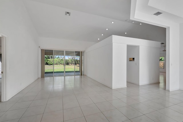 spare room featuring visible vents, plenty of natural light, light tile patterned floors, and high vaulted ceiling
