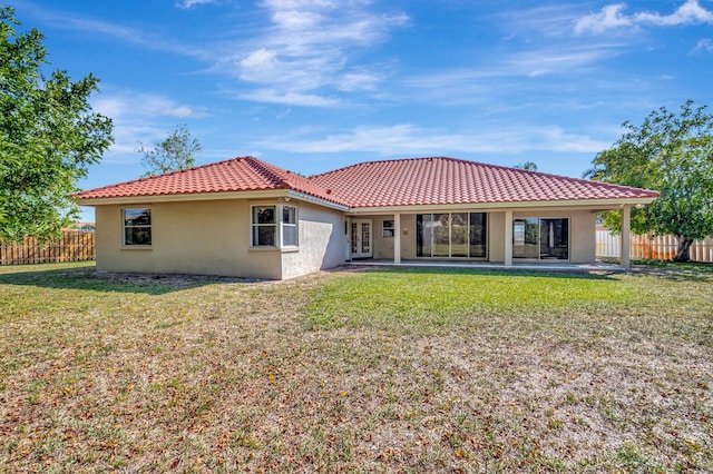 rear view of property featuring stucco siding, french doors, and fence