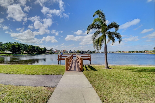 view of dock featuring a water view and a yard