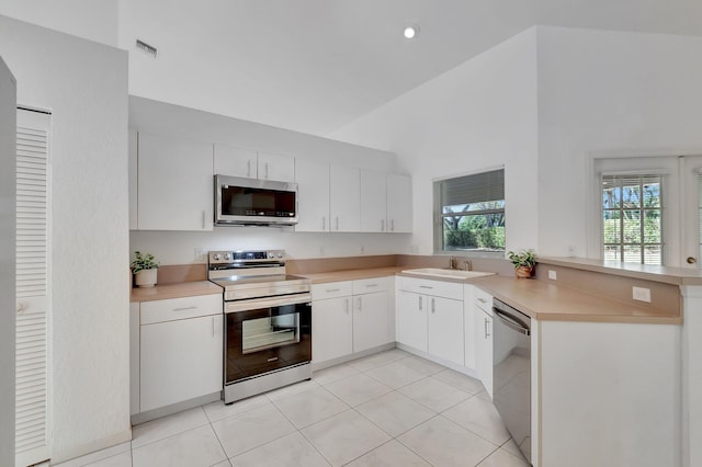 kitchen featuring a sink, appliances with stainless steel finishes, a peninsula, and light countertops