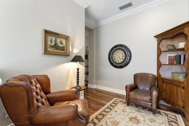 sitting room featuring visible vents, baseboards, crown molding, and wood finished floors