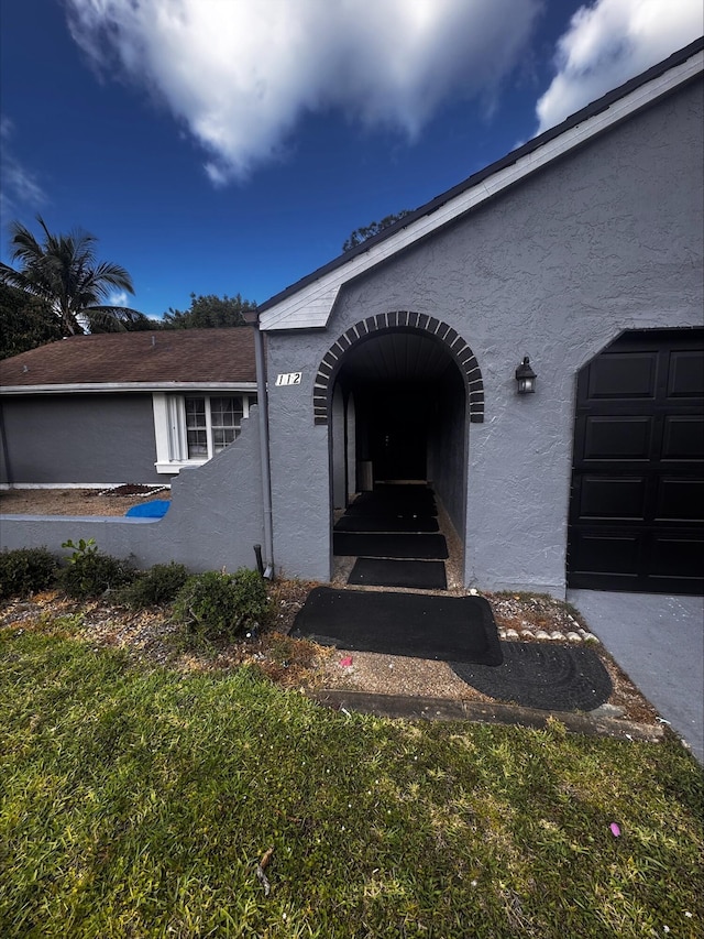 entrance to property featuring stucco siding