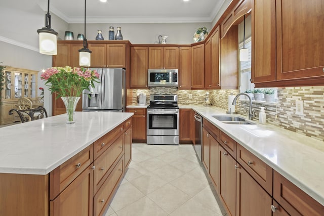 kitchen featuring brown cabinetry, appliances with stainless steel finishes, tasteful backsplash, hanging light fixtures, and a sink