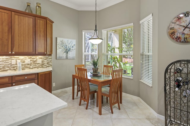 dining area with crown molding, baseboards, and light tile patterned floors