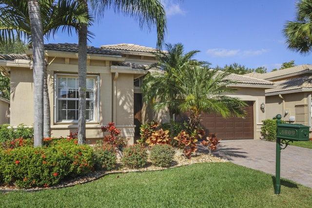 view of front facade featuring an attached garage, stucco siding, and a tile roof