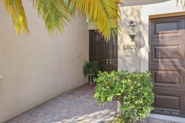 doorway to property featuring stucco siding
