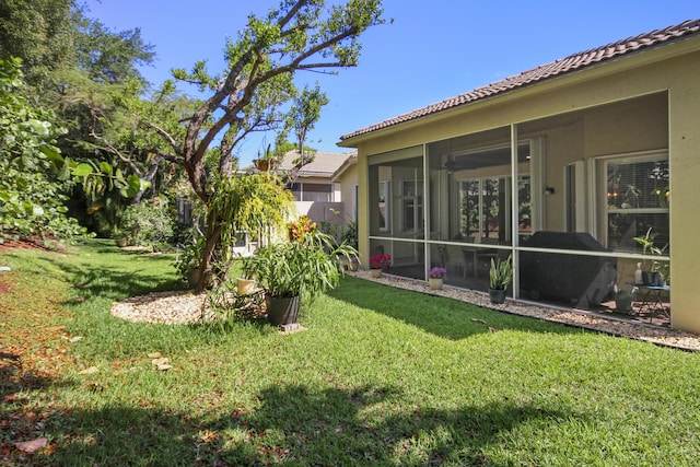 view of yard featuring fence and a sunroom