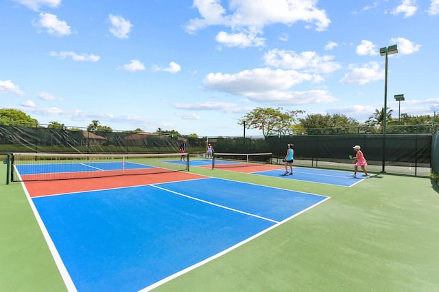 view of tennis court featuring fence and community basketball court