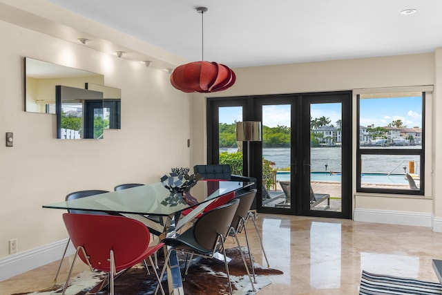 dining area with a water view, marble finish floor, baseboards, and french doors